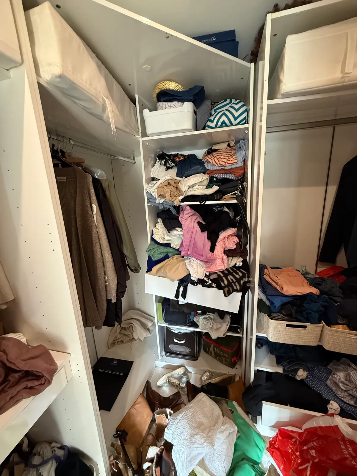 Colonne d'étagères du dressing avant le tri, vêtements entassés en vrac