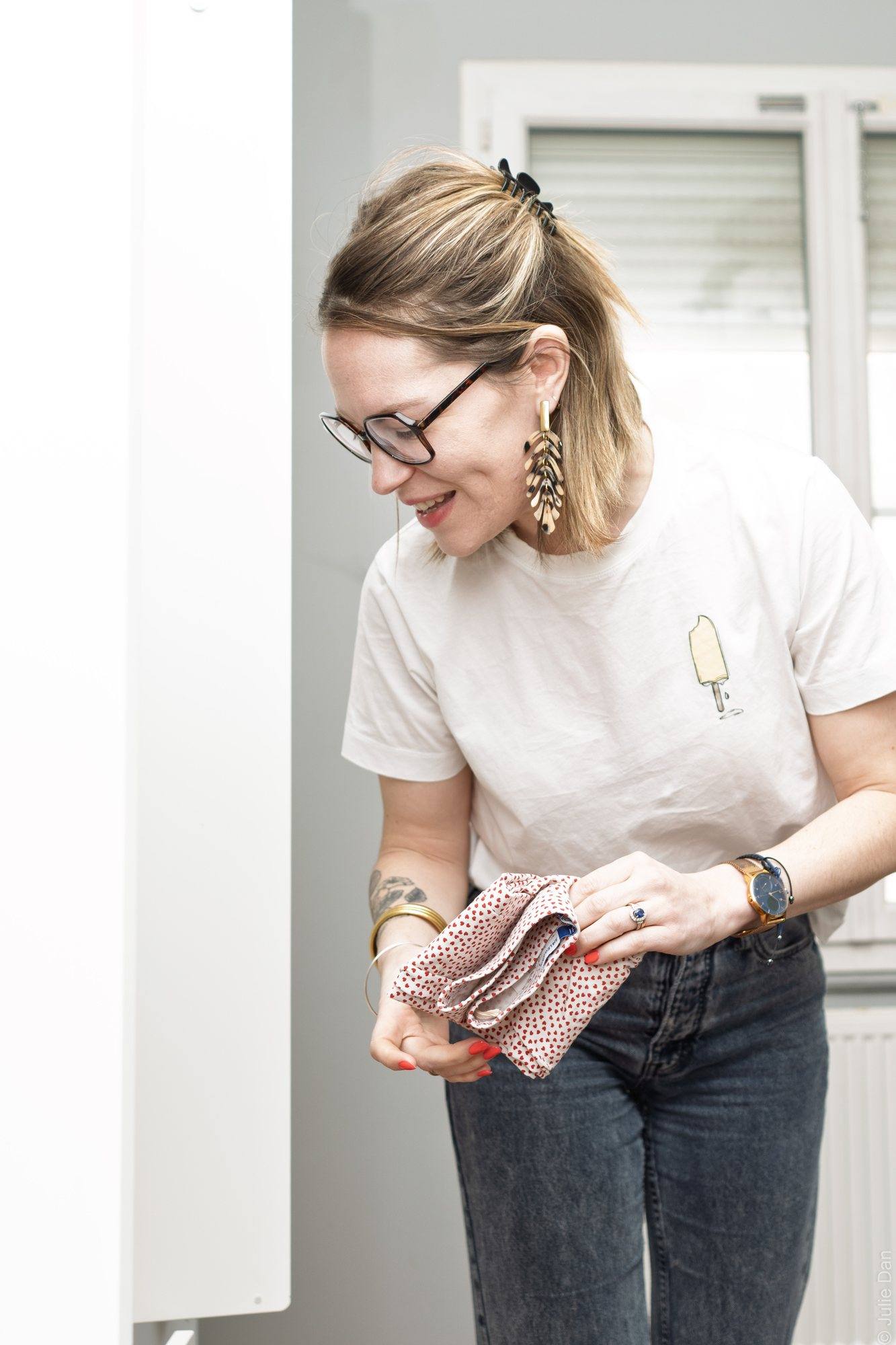 Virginie Pinsault plie un linge devant une armoire ouverte