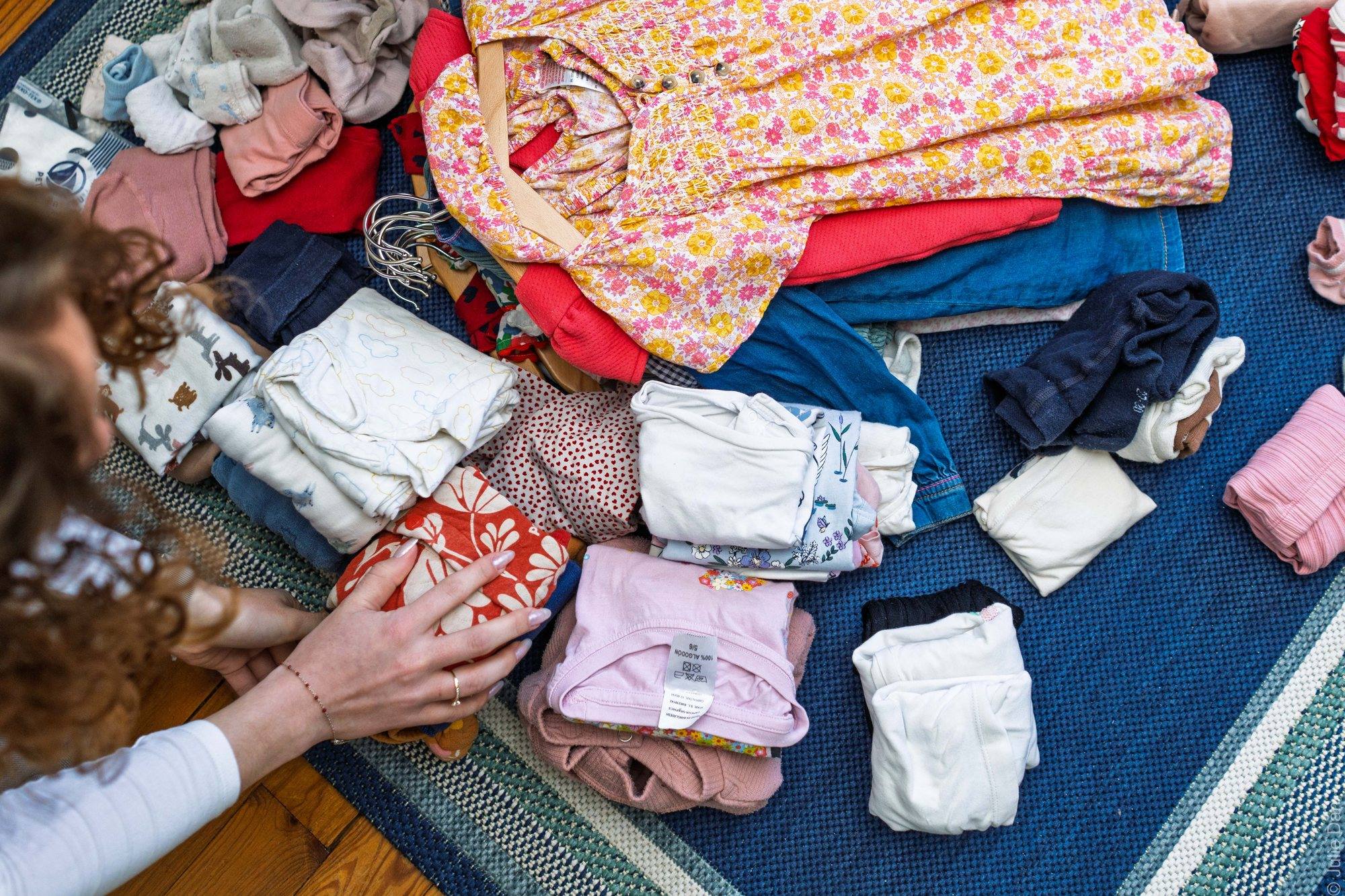 Vêtements d'enfant triés en piles sur un tapis